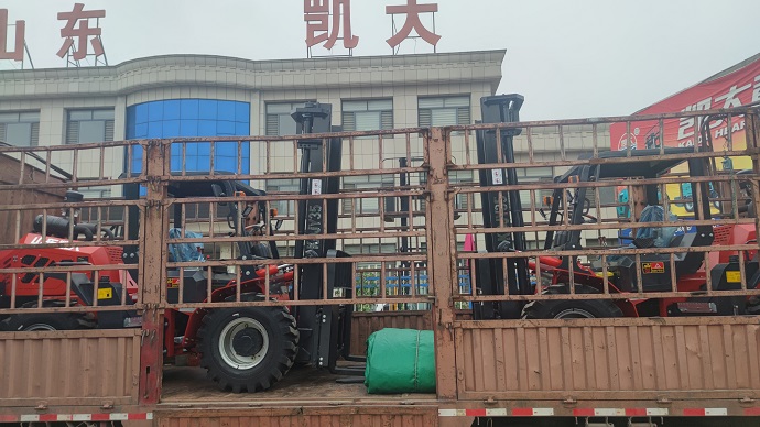 A photo of two Kaystar Landtiger35Pro off-road forklifts with customized features being loaded on a transport truck in a Chinese factory.
