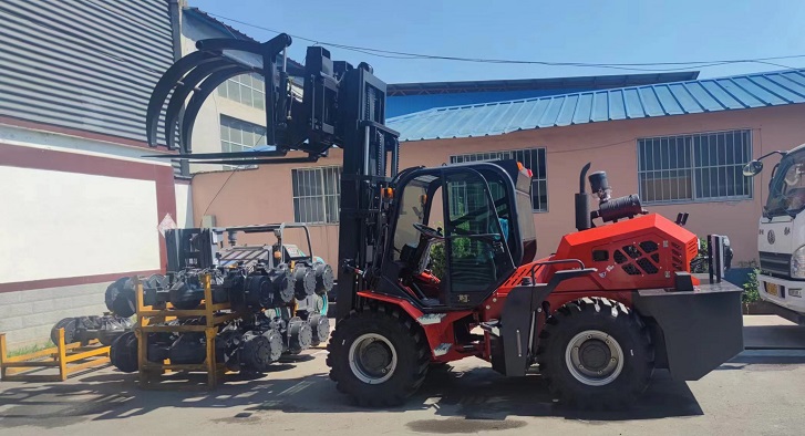 A photo shows a custom forklift picking up scrap metal and grass at a dump. The forklift is a Kaystar Landtiger35Pro model, with articulated four-wheel drive function, equipped with special grabbing attachments and a closed cab. The grabbing attachment can be turned up and down 90 degrees, which is convenient for loading and unloading bulk goods.