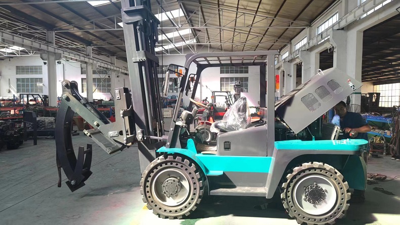 A photo showing a custom forklift being produced at the Kaystar forklift factory. The forklift is a Kaystar Pioneer30 model, with four-wheel drive and four-steering functions, and is equipped with special steel pipe clamp attachments and solid off-road tires. Steel pipes come in different diameters and lengths, with the longest reaching 6 meters and the heaviest reaching 600 kilograms.