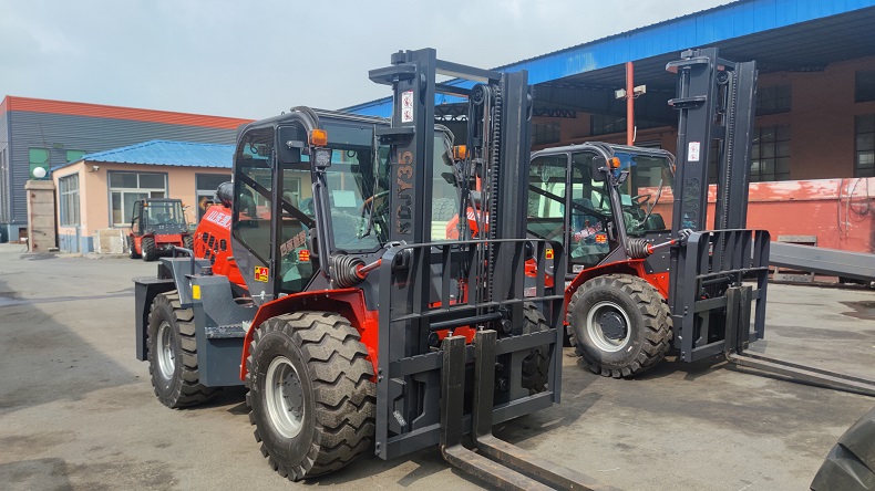 A photo of two customized Landtiger35Pro articulated 4WD forklifts at Kaystar factory, with different mast heights of 3 meters and 4 meters, respectively. The photo also shows the right  side front views of the two forklifts.