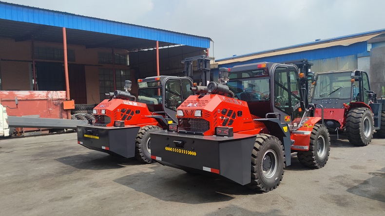 A photo of two customized Landtiger35Pro articulated 4WD forklifts at Kaystar factory, with different mast heights of 3 meters and 4 meters, respectively. The photo also shows the rear view of the two forklifts.