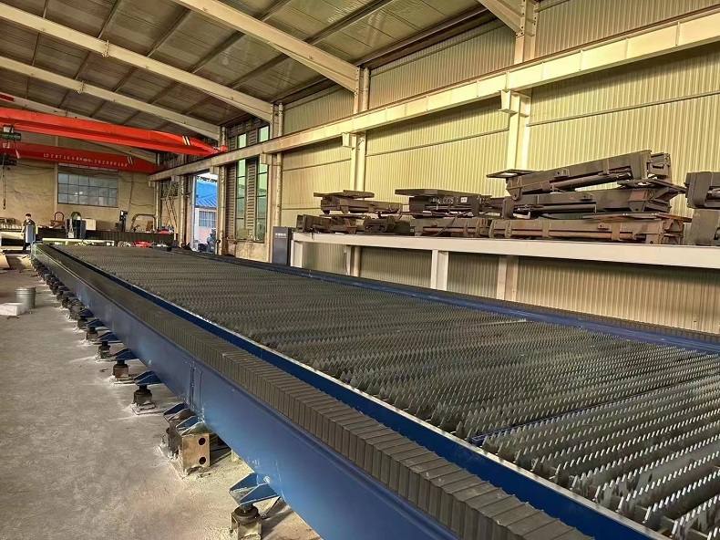  close-up view of the laser cutting machine’s head as it cuts through a thick metal sheet.