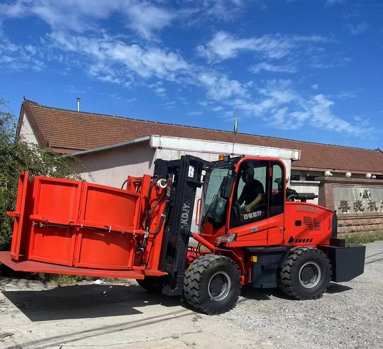 A photo of a red Kaystar Landtiger35 customized off-road forklift with a cylindrical clamp and pusher attachment parked on a concrete floor in front of a warehouse. The photo shows the side view of the forklift, with its mast lowered and its clamp empty. The photo also shows the logo of Kaystar on the side of the forklift and on its tire. The photo has a caption that reads: “Meet the Kaystar Landtiger35: A Customized Off-Road Forklift for Tough Terrain”.