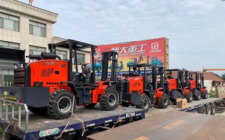Four landtiger26 articulated four-wheel drive off-road forklifts with a load of 3 tons are waiting for transportation.