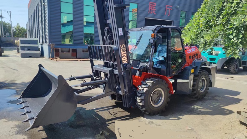 A photo of a Kaystar KDJY35 forklift with a black bucket attached to its forks, show out in the all-terrain forklift factory.