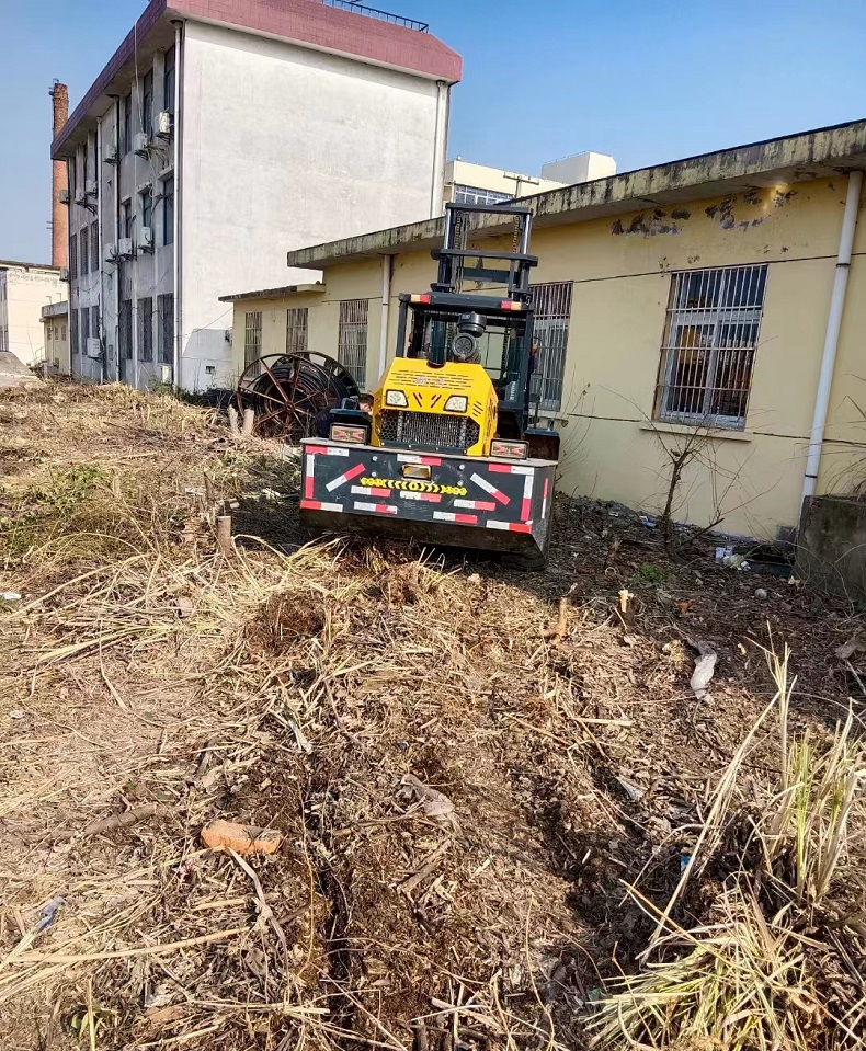A Chinese-made 3.5-ton small four-wheel drive all-terrain forklift transports goods on uneven roads.